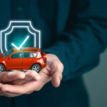 assurance, confidence, certificate, certification, guarantee, insurance, protect, security, safety, warranty. A man is holding a toy car with a check mark on it. Concept of security and protection.